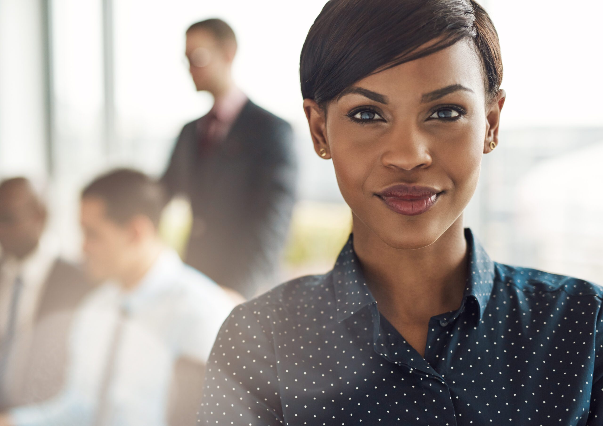 Confident business woman in office with group News